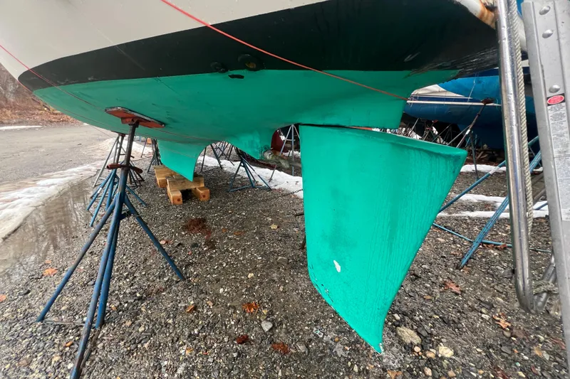 Slide: The Image of 1993 Com-Pac Sloop sailboat on stands, showing green keel and hull. - 22