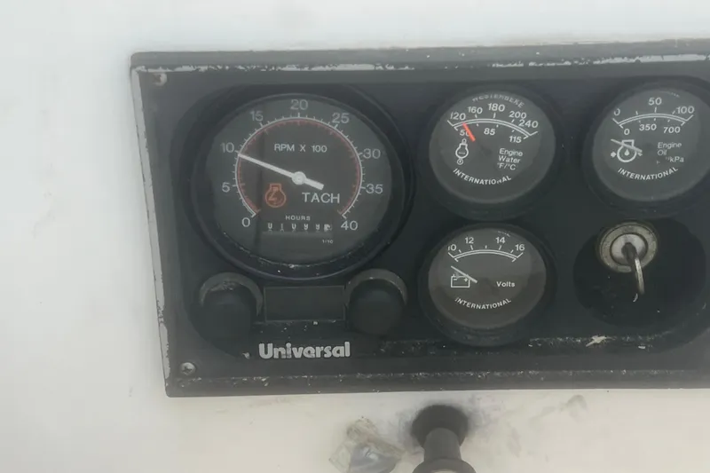 Slide: The Image of Dashboard of a 1993 Com-Pac Sloop showing tachometer and engine gauges. - 25