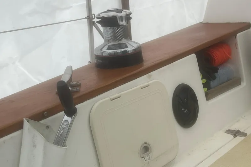 Slide: The Image of 1993 Com-Pac Sloop sailboat cockpit with winch, storage, and control handle. - 27
