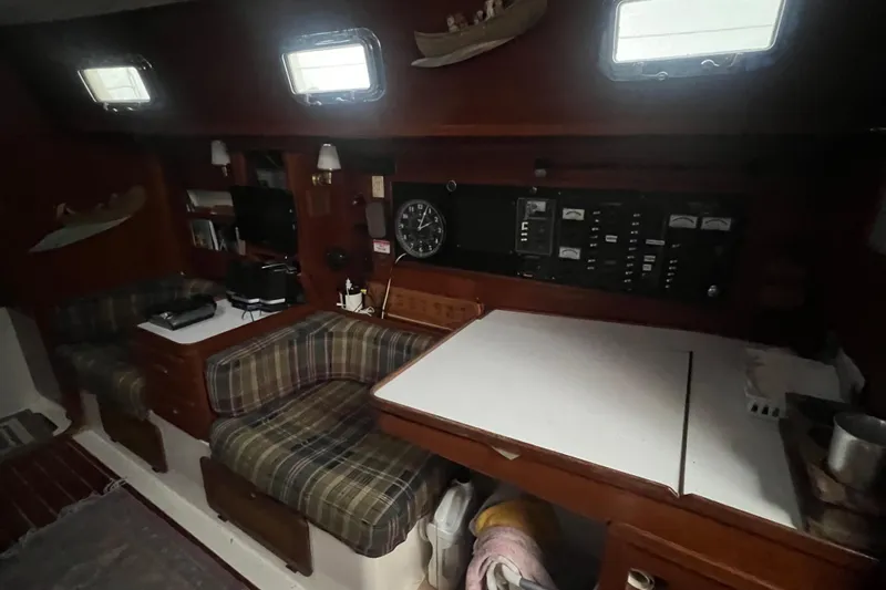 Slide: The Image of Interior of a 1993 Com-Pac Sloop sailboat with seating and control panels. - 30