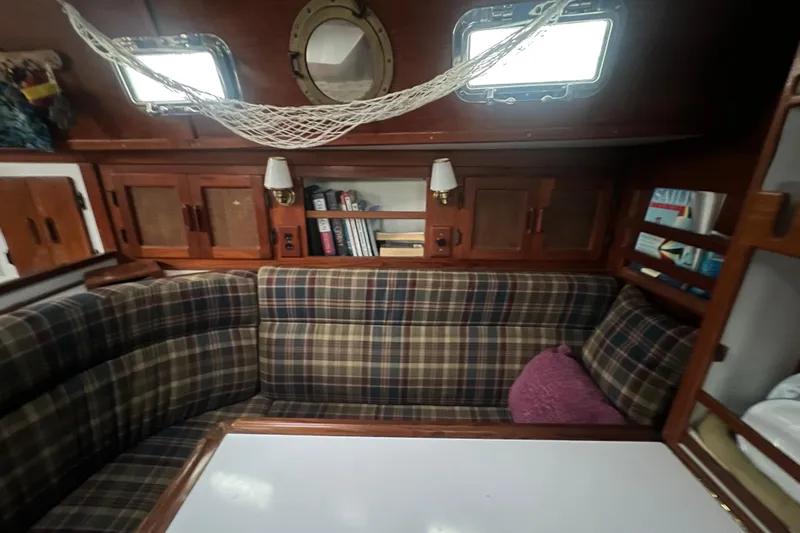 Slide: The Image of Cozy interior of 1993 Com-Pac Sloop with plaid seating and wooden cabinetry. - 34