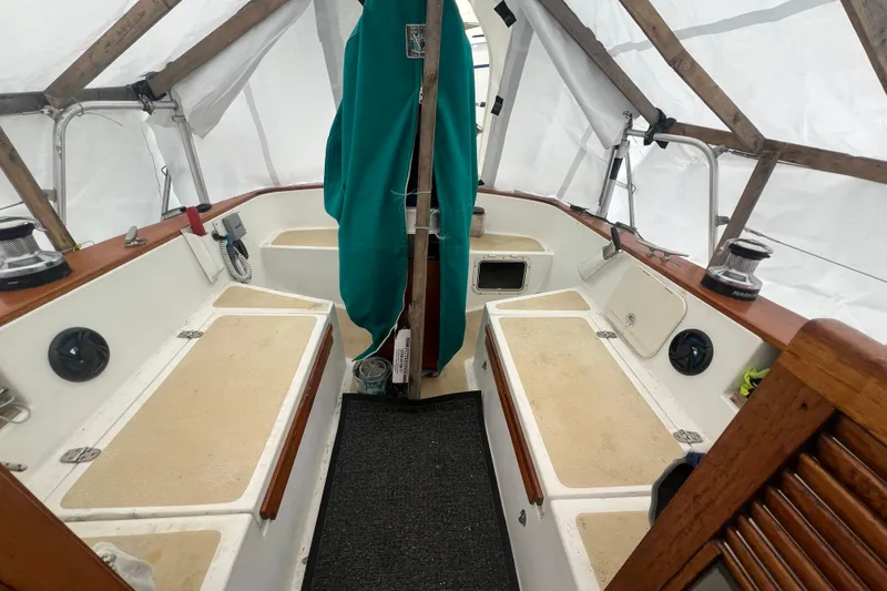Slide: The Image of 1993 Com-Pac Sloop interior with seating, winches, and covered deck. - 38