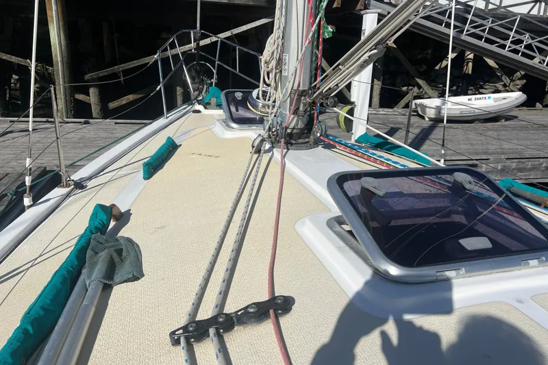 Slide: The Image of 1993 Compac Sloop sailboat deck with rigging and hatches, docked at a marina. - 8