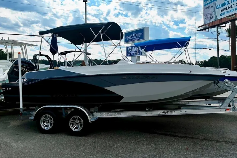Slide: The Image of 2026 Starcraft SVX 211 OB boat on trailer, featuring sleek design and bimini top. - 1