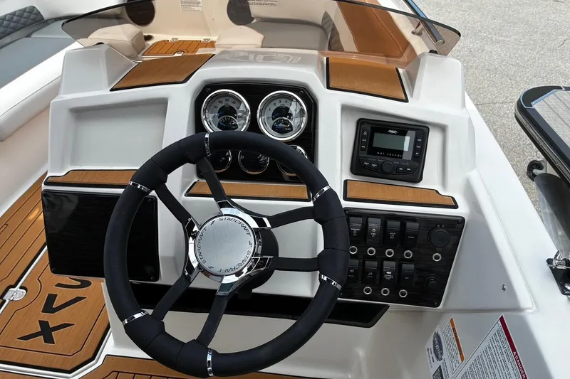 Slide: The Image of 2026 Starcraft SVX 211 OB boat dashboard with steering wheel and control panel. - 13