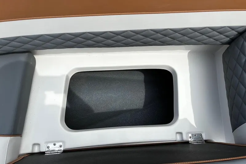 Slide: The Image of Starcraft SVX 211 OB 2026 boat storage compartment with quilted upholstery detail. - 19