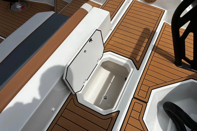 Slide: The Image of 2026 Starcraft SVX 211 OB boat deck with open storage compartment and teak-style flooring. - 6
