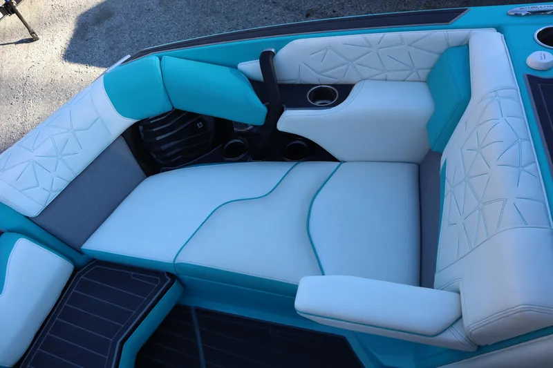 Slide: The Image of Luxurious seating in 2021 Nautique Super Air Nautique G23 Paragon boat, featuring teal and white upholstery. - 13