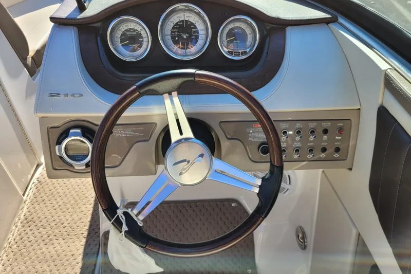 Slide: The Image of 2013 Sea Ray 210 SLX dashboard with steering wheel and control panel. - 10