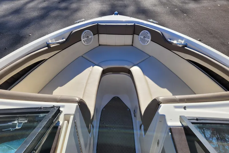 Slide: The Image of 2013 Sea Ray 210 SLX boat interior with beige seating and speakers. - 11