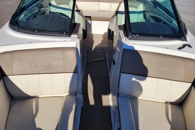 Slide: The Image of 2013 Sea Ray 210 SLX boat interior with beige seating and dual windshields. - 12