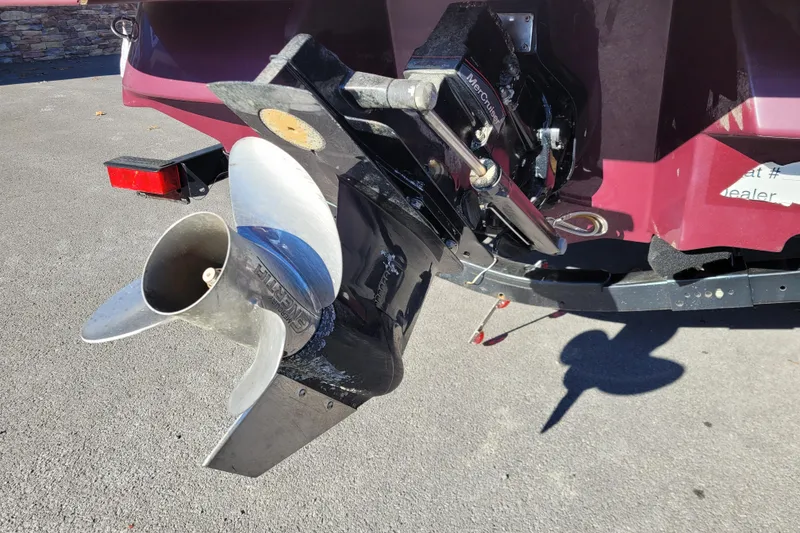 Slide: The Image of 2013 Sea Ray 210 SLX boat with MerCruiser outdrive and propeller, parked on pavement. - 15