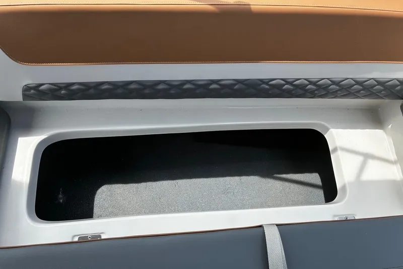 Slide: The Image of Open storage compartment on 2026 Starcraft SVX 211 OB boat, featuring cushioned seating. - 10