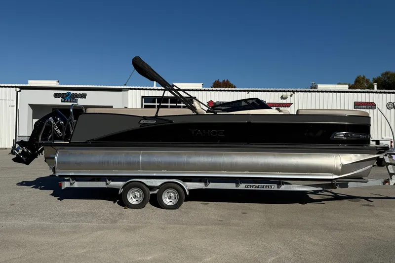 Slide: The Image of 2026 Tahoe Pontoon Cascade Quad Lounger Windshield on trailer, parked outside marine dealership. - 1