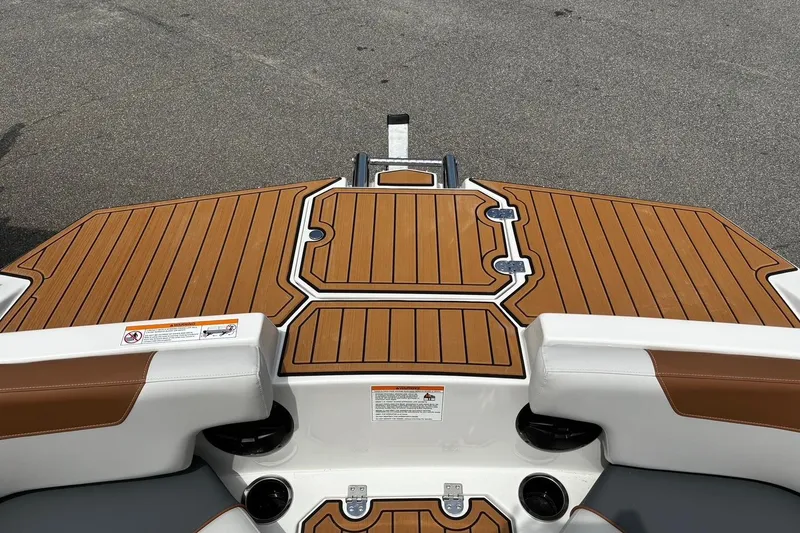 Slide: The Image of 2026 Starcraft SVX 211 OB boat deck with brown and white seating, cup holders, and wood finish. - 21