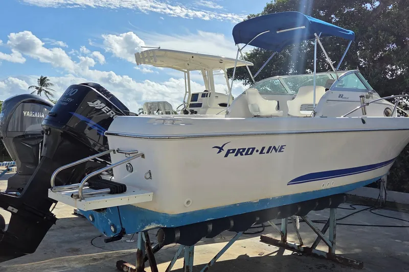 The Image of 2001 Pro-Line 22 Walk boat with blue canopy and dual outboard motors. - 0