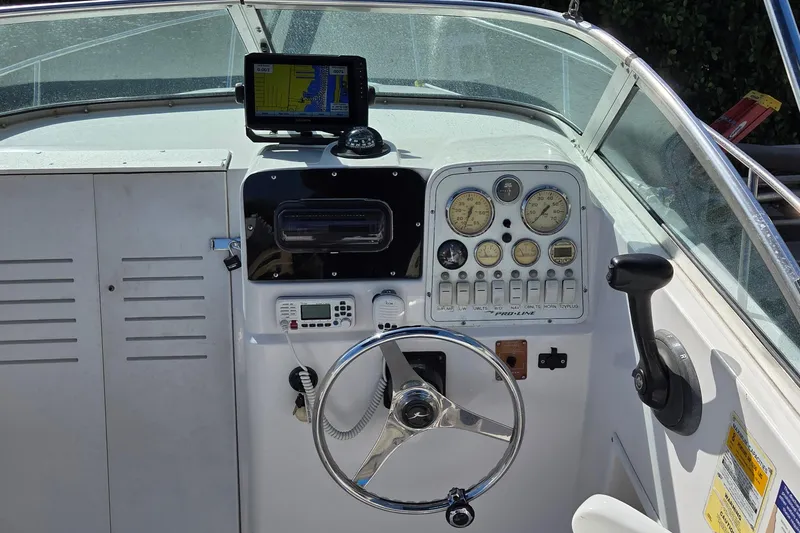 Slide: The Image of 2001 Pro-Line 22 Walk boat dashboard with steering wheel, gauges, and navigation equipment. - 6