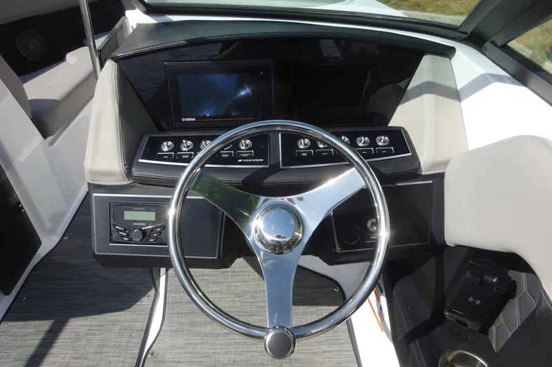 Slide: The Image of 2022 Four Winns H4 OB boat dashboard with steering wheel and control panel. - 14