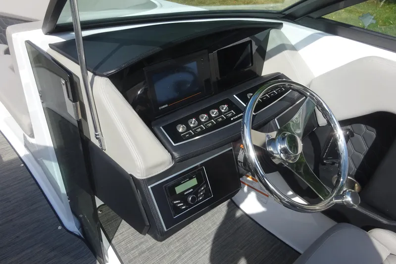 Slide: The Image of 2022 Four Winns H4 OB boat dashboard with steering wheel and control panel. - 15