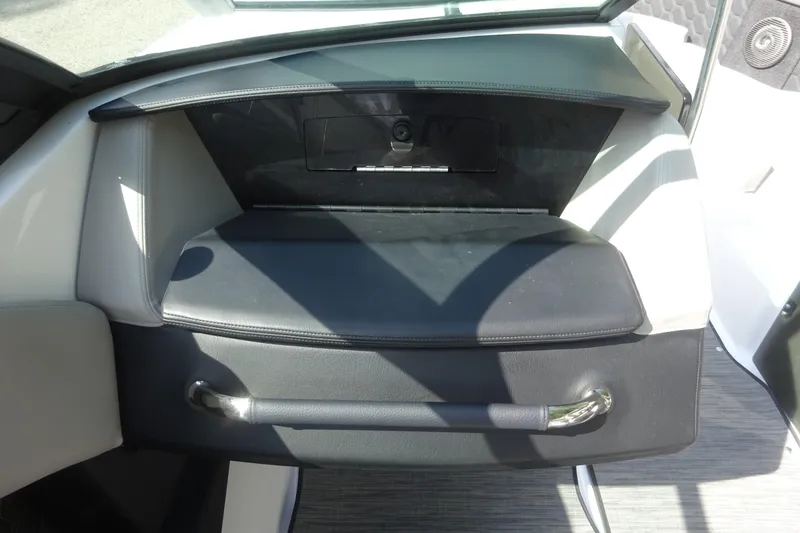 Slide: The Image of Interior of 2022 Four Winns H4 OB boat, featuring a sleek black dashboard and storage compartment. - 16