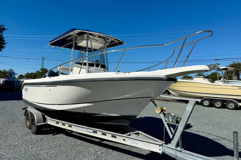Slide: The Image of 2001 Boston Whaler 230 Outrage boat on trailer, under clear blue sky. - 11