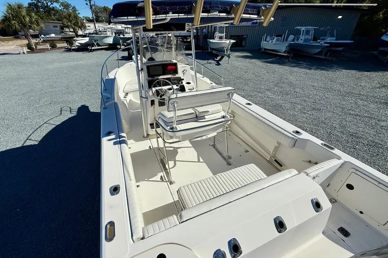 Slide: The Image of 2001 Boston Whaler 230 Outrage boat interior with seating and console, parked outdoors. - 13
