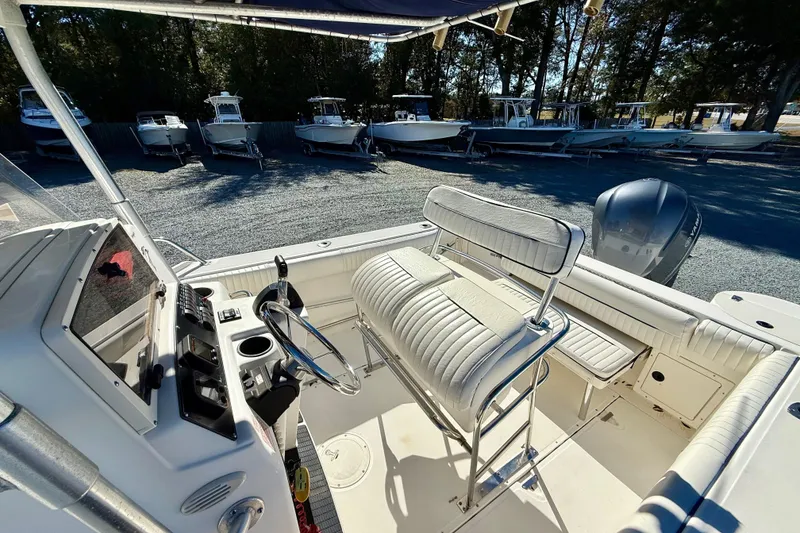 Slide: The Image of 2001 Boston Whaler 230 Outrage boat interior with steering wheel and seating. - 18