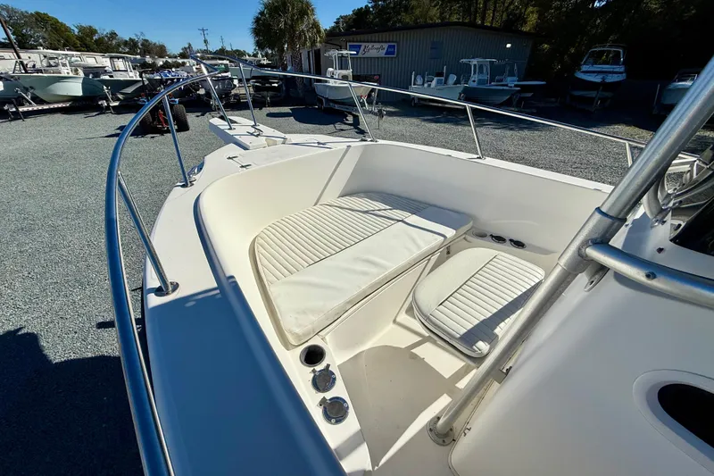 Slide: The Image of 2001 Boston Whaler 230 Outrage boat interior with cushioned seating and railings. - 27