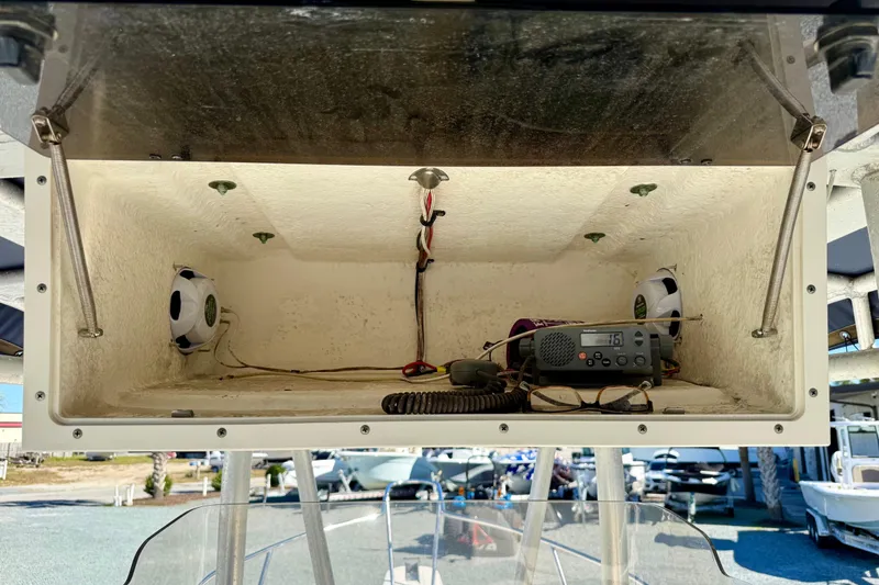 Slide: The Image of Storage compartment on a 2001 Boston Whaler 230 Outrage boat with radio and speakers. - 32