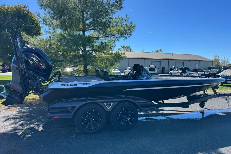 The Image of 2026 Skeee FXR 21 Flex boat on trailer, parked outdoors near trees and buildings. - 1