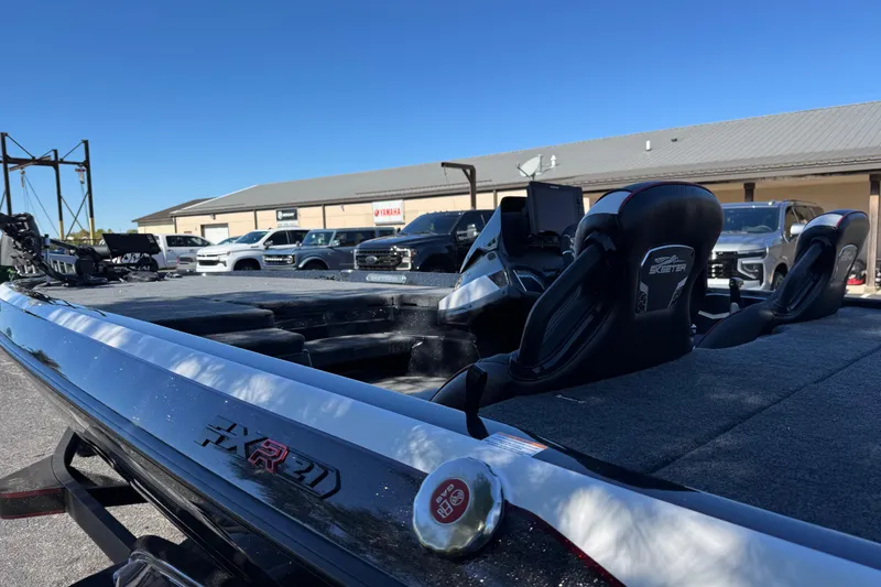 Slide: The Image of 2026 Skeee FXR 21 Flex boat with sleek design, parked outdoors under clear blue sky. - 6