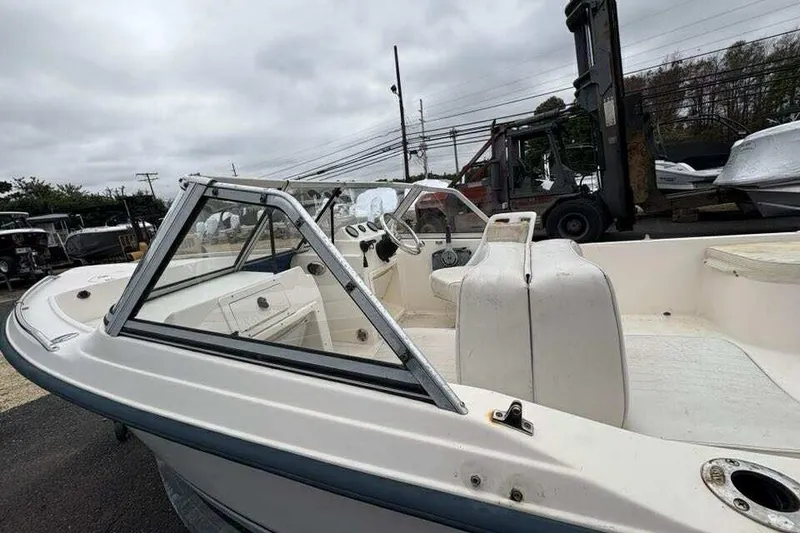 Slide: The Image of 2006 Key West 1720 Dual Console boat, white interior, parked outdoors on a cloudy day. - 8