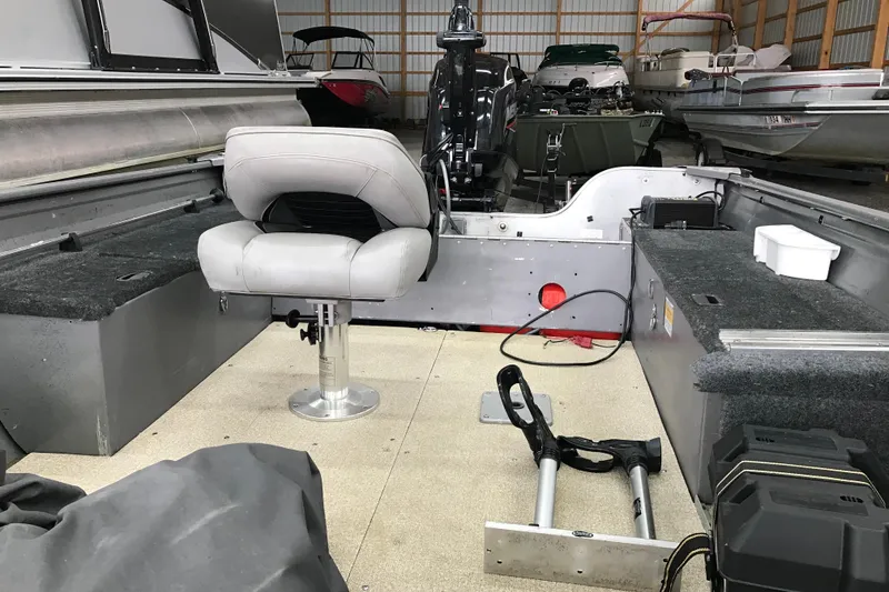 Slide: The Image of 2004 Crestliner Canadian 18 Tiller boat interior with seating and equipment in storage. - 10