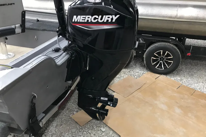 Slide: The Image of 2004 Crestliner Canadian 18 Tiller with Mercury outboard motor on gravel. - 4