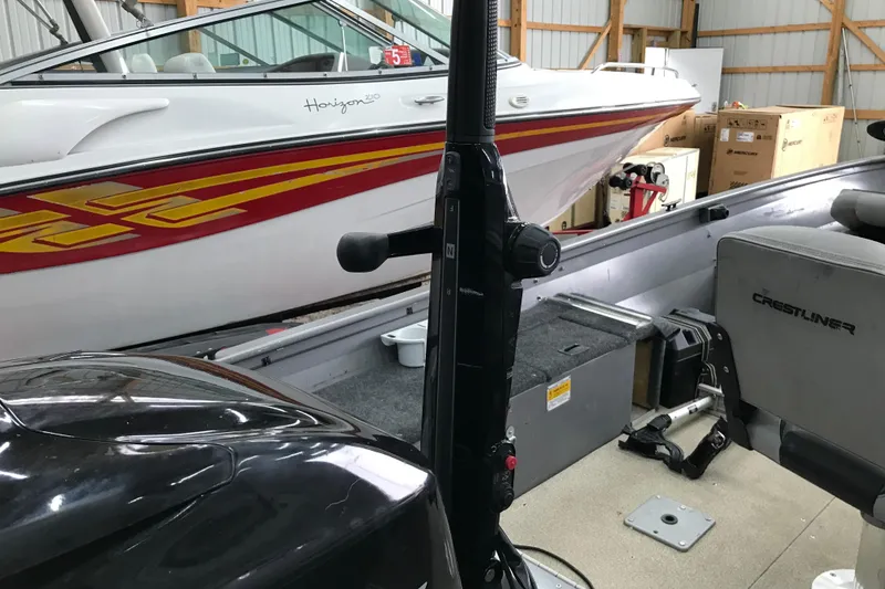 Slide: The Image of 2004 Crestliner Canadian 18 Tiller boat interior with motor and seating in storage. - 6