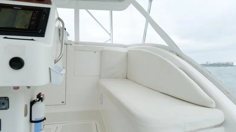 Slide: The Image of 2006 Out Island 38 Express boat interior with white seating and control panel. - 18