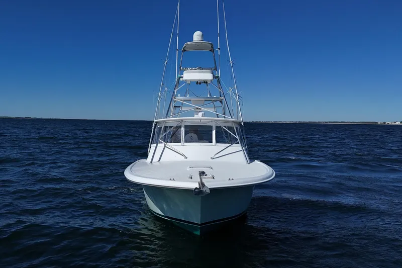 Slide: The Image of 2006 Out Island 38 Express boat on open water under clear blue sky. - 2