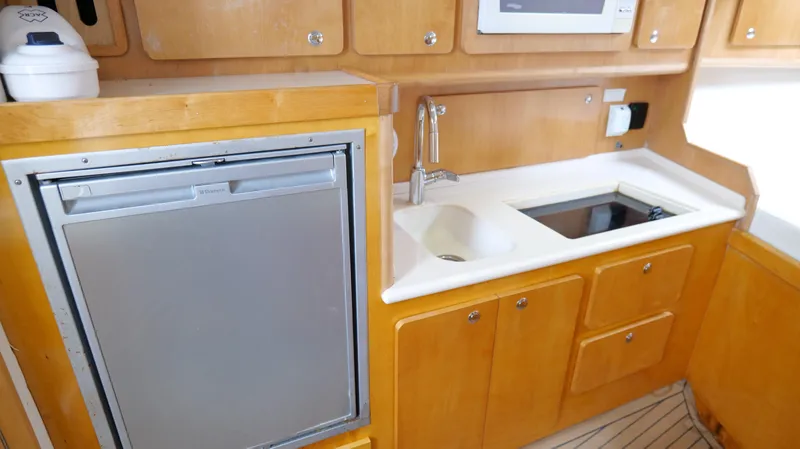 Slide: The Image of 2006 Out Island 38 Express yacht kitchen with sink, stove, and refrigerator. - 23