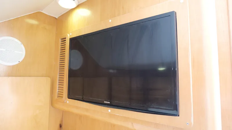 Slide: The Image of Flat-screen TV mounted on wood panel inside 2006 Out Island 38 Express boat. - 28