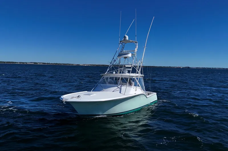 Slide: The Image of 2006 Out Island 38 Express boat cruising on open water under clear blue sky. - 3