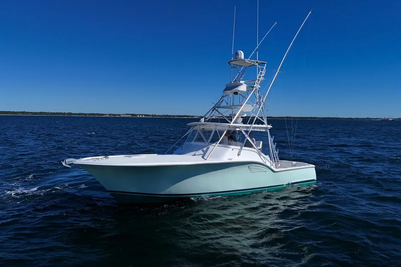 Slide: The Image of 2006 Out Island 38 Express boat cruising on open water under clear blue sky. - 4