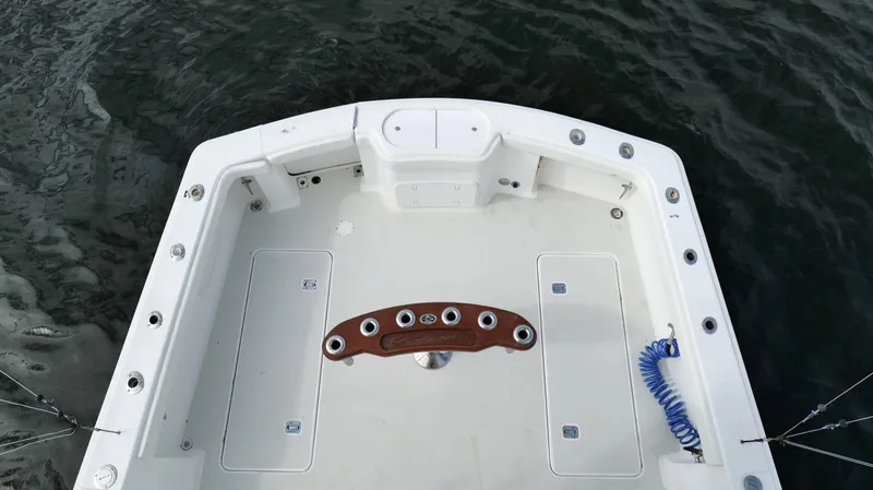 Slide: The Image of 2006 Out Island 38 Express boat deck with rod holders and coiled blue hose. - 40