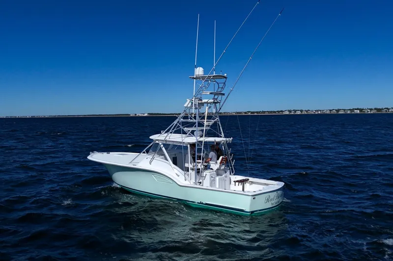 Slide: The Image of 2006 Out Island 38 Express boat cruising on open water under clear blue sky. - 6