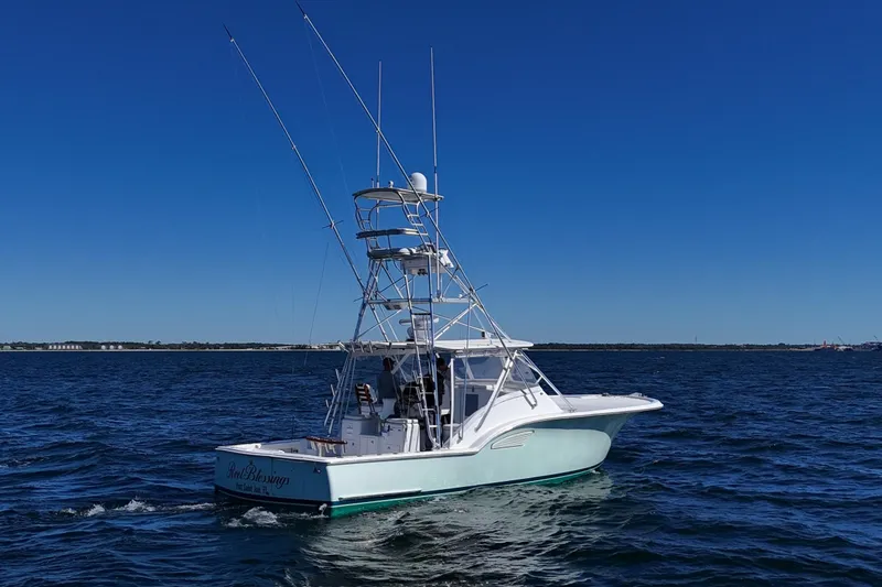 Slide: The Image of 2006 Out Island 38 Express boat cruising on open water under clear blue sky. - 8