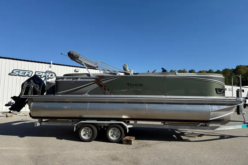 The Image of 2026 Tahoe Pontoon LTZ Quad Lounger on trailer, parked outdoors under clear blue sky. - 0
