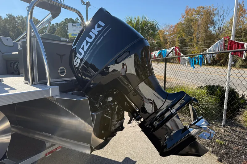 Slide: The Image of 2026 Tahoe Pontoon LTZ Quad Lounger with Suzuki outboard motor, parked outdoors. - 4