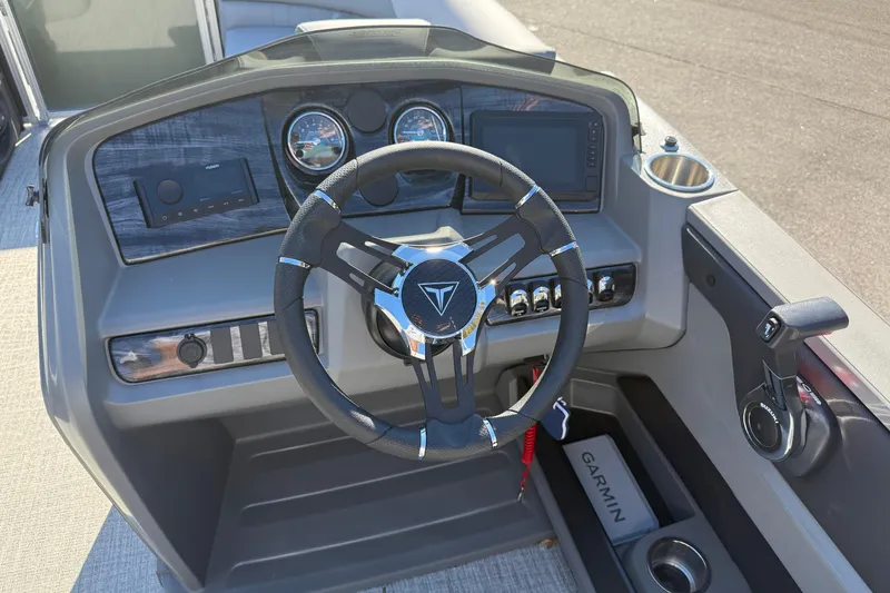 Slide: The Image of 2026 Tahoe Pontoon LTZ Quad Lounger dashboard with steering wheel and Garmin navigation system. - 7