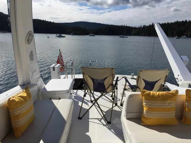 Slide: The Image of 1994 Bayliner 4788 Pilot House Motoryacht deck with chairs, cushions, and scenic water view. - 17