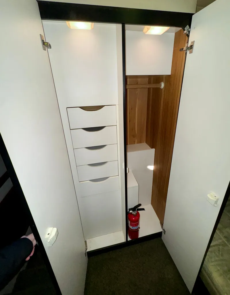 Slide: The Image of 1994 Bayliner 4788 Pilot House Motoryacht interior closet with drawers and fire extinguisher. - 18
