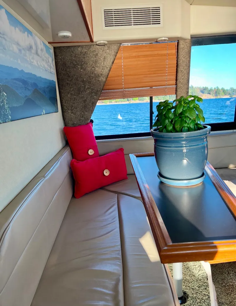 Slide: The Image of Interior of 1994 Bayliner 4788 Pilot House Motoryacht with seating, table, and potted plant. - 5